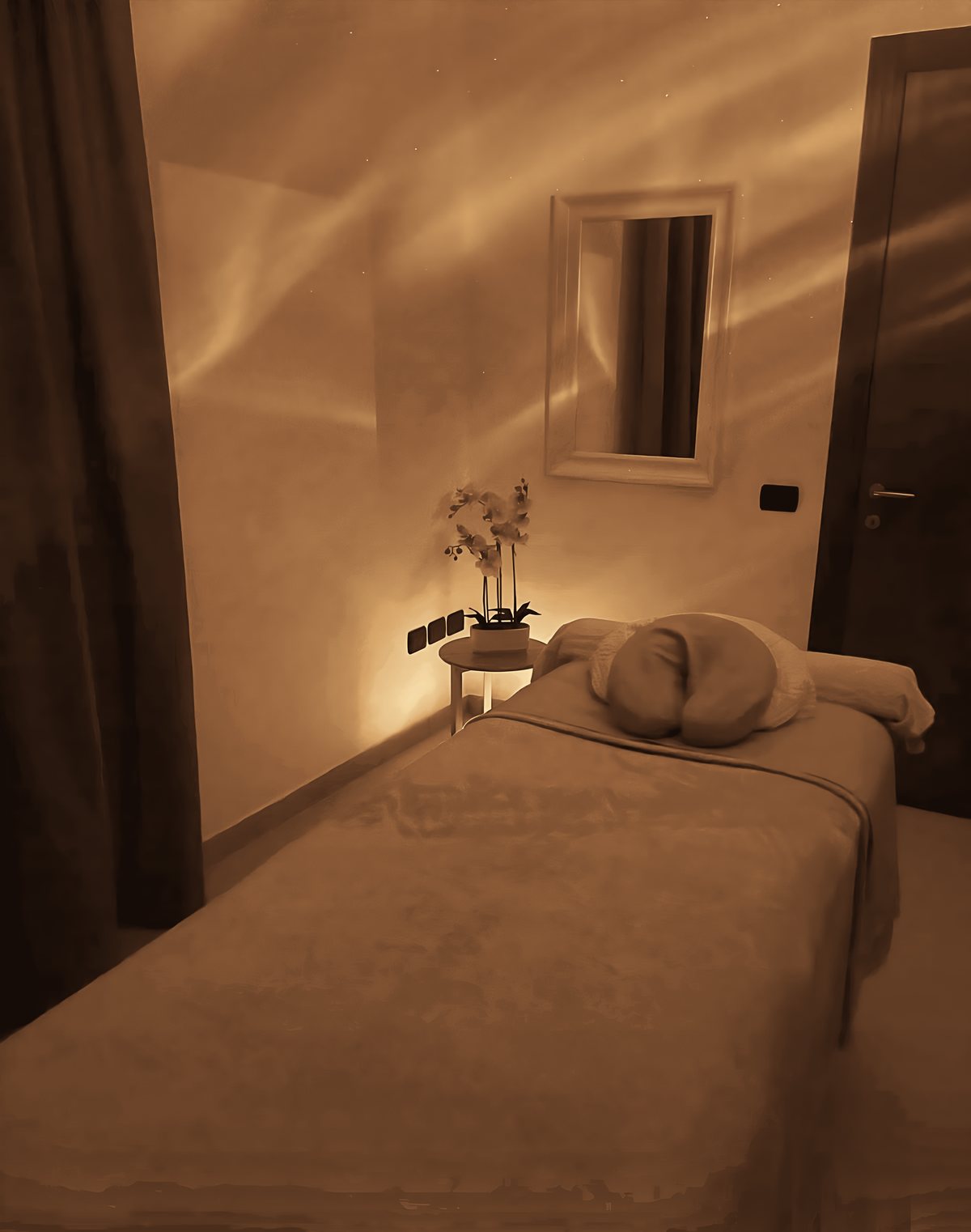 Sala de tratamientos de Oi Spa con camilla, luz cálida y una orquídea